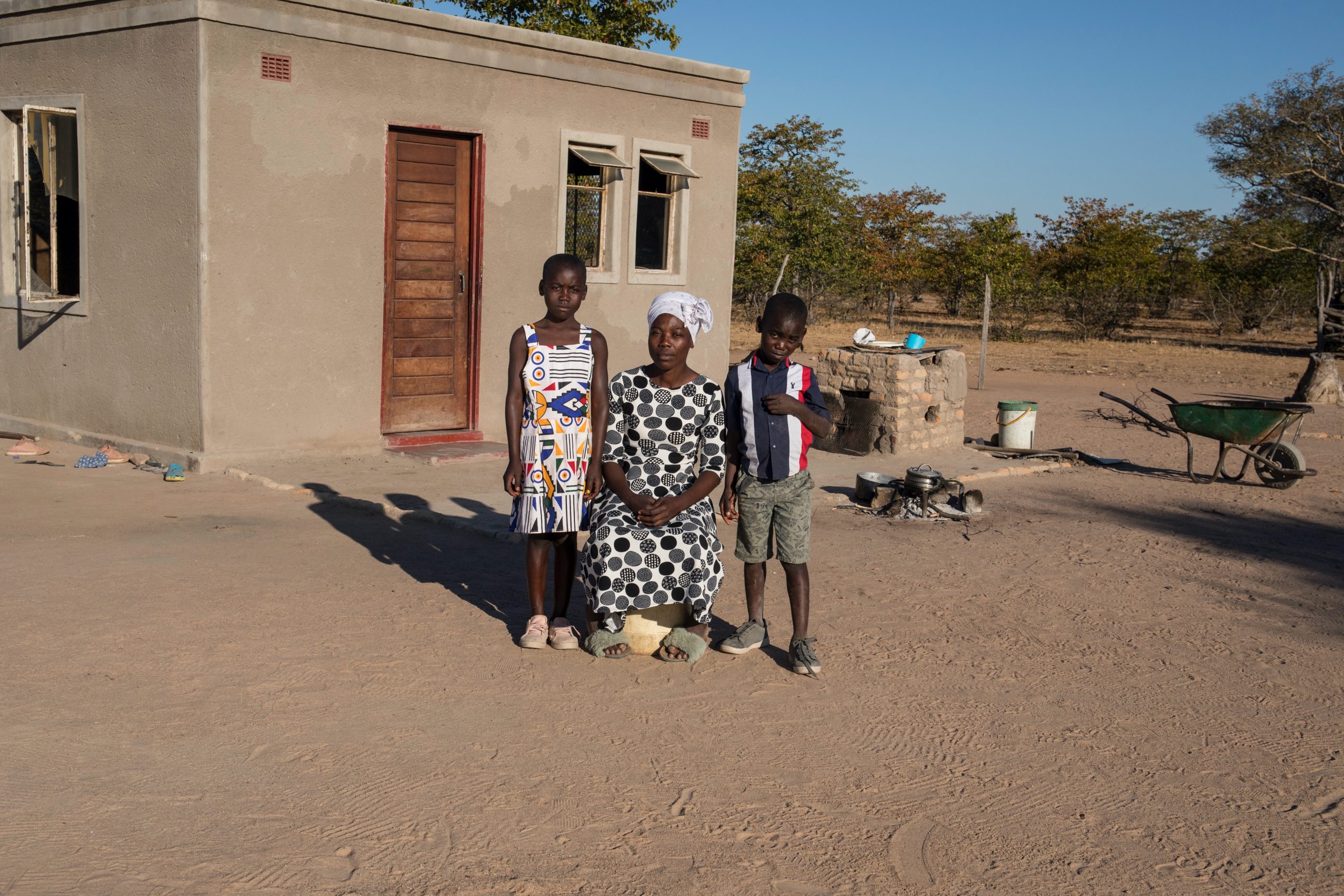 Thandekile, 31, with daughter Nomatter, 11 and son, Forward, 8, at their home in Matabeleland, Zimbabwe. The children lost their father to COVID-19 in 2020 while he was working in South Africa to provide for the family Photo Credit: Cynthia R Matonhodze
