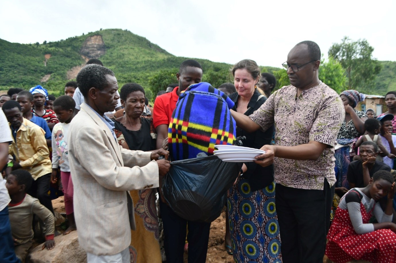 Catholic University’s Vice Chancellor, Rev. Fr. Dr. George Buley, and Trócaire Country Director Jeannette Wijnants hand over aid packs to Ntauchire Village Chief, Mr. Lucius Hanke